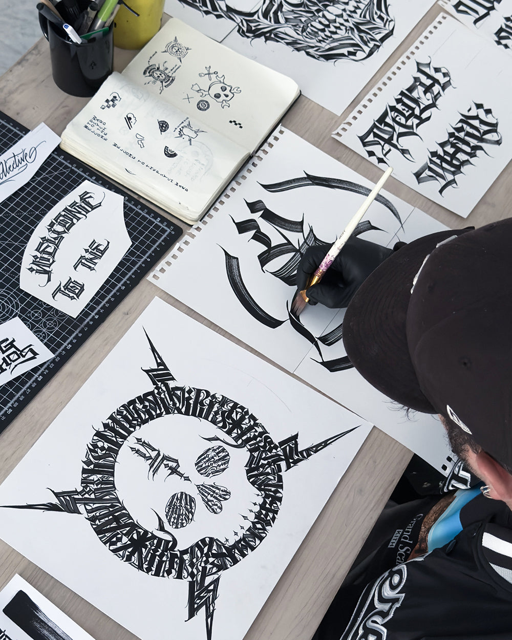 Person working on Young Psychos designs with a focus on black and white artwork.