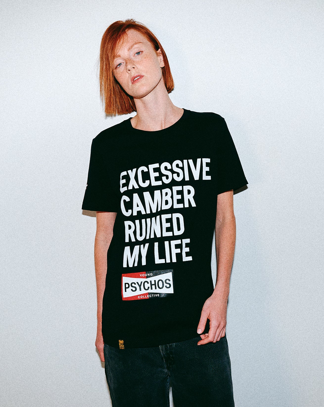 Person wearing a black t-shirt with text on a plain background