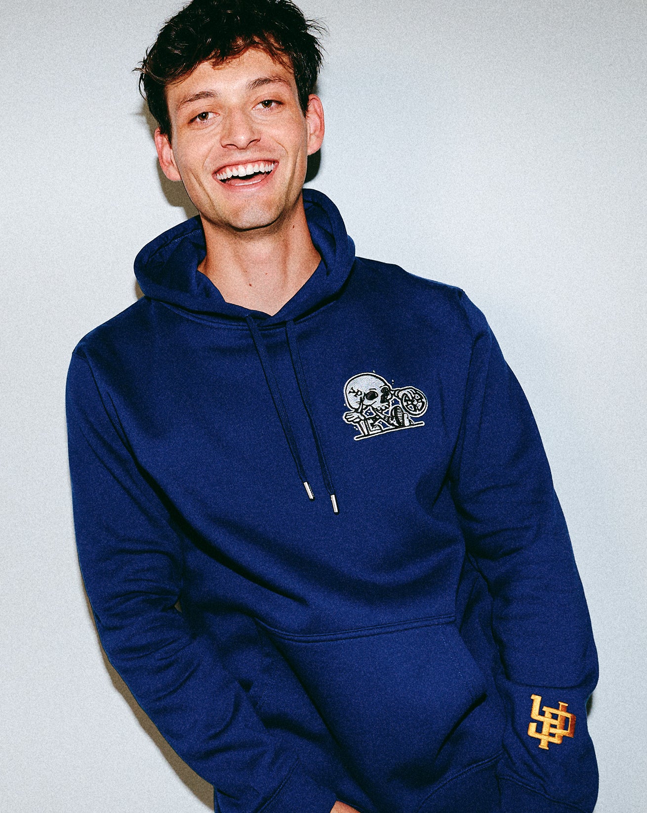 Person wearing a blue hoodie with a Young Psychos logo on a plain background