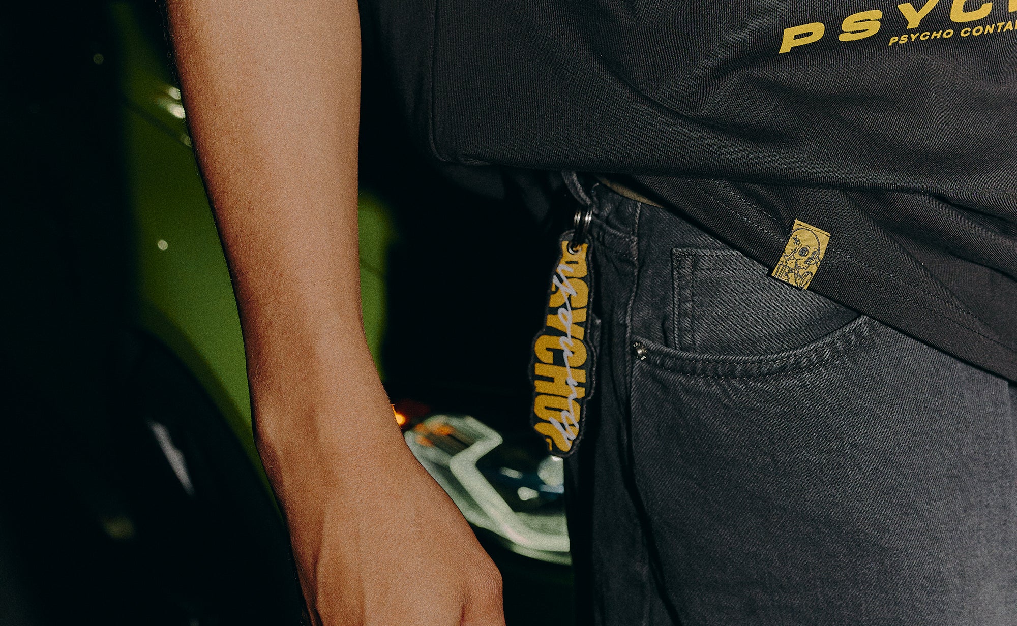 Person wearing a black t-shirt with 'YOUNG PSYCHO' branding and dark pants.