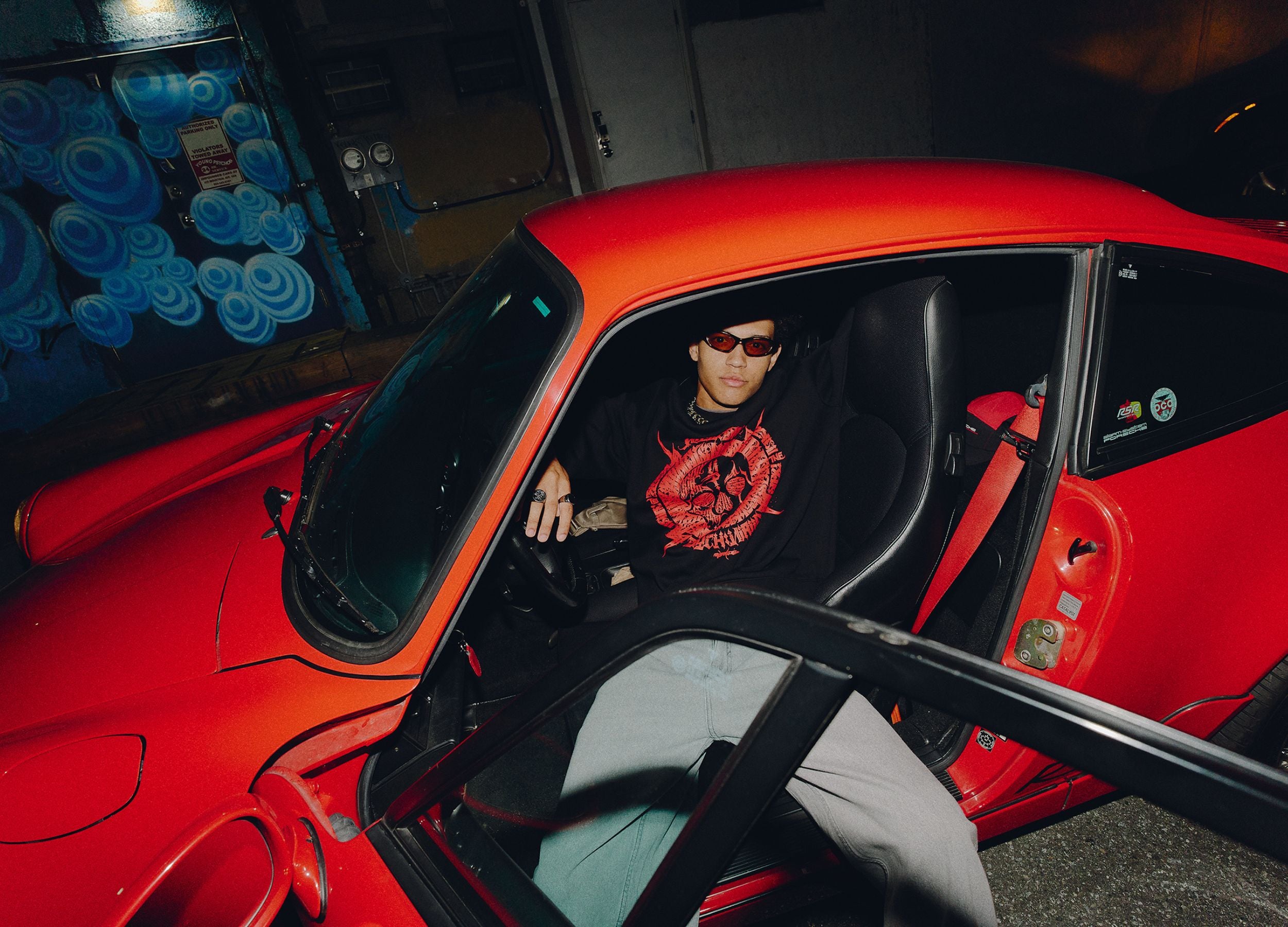 Person sitting inside a red car with a dark interior.