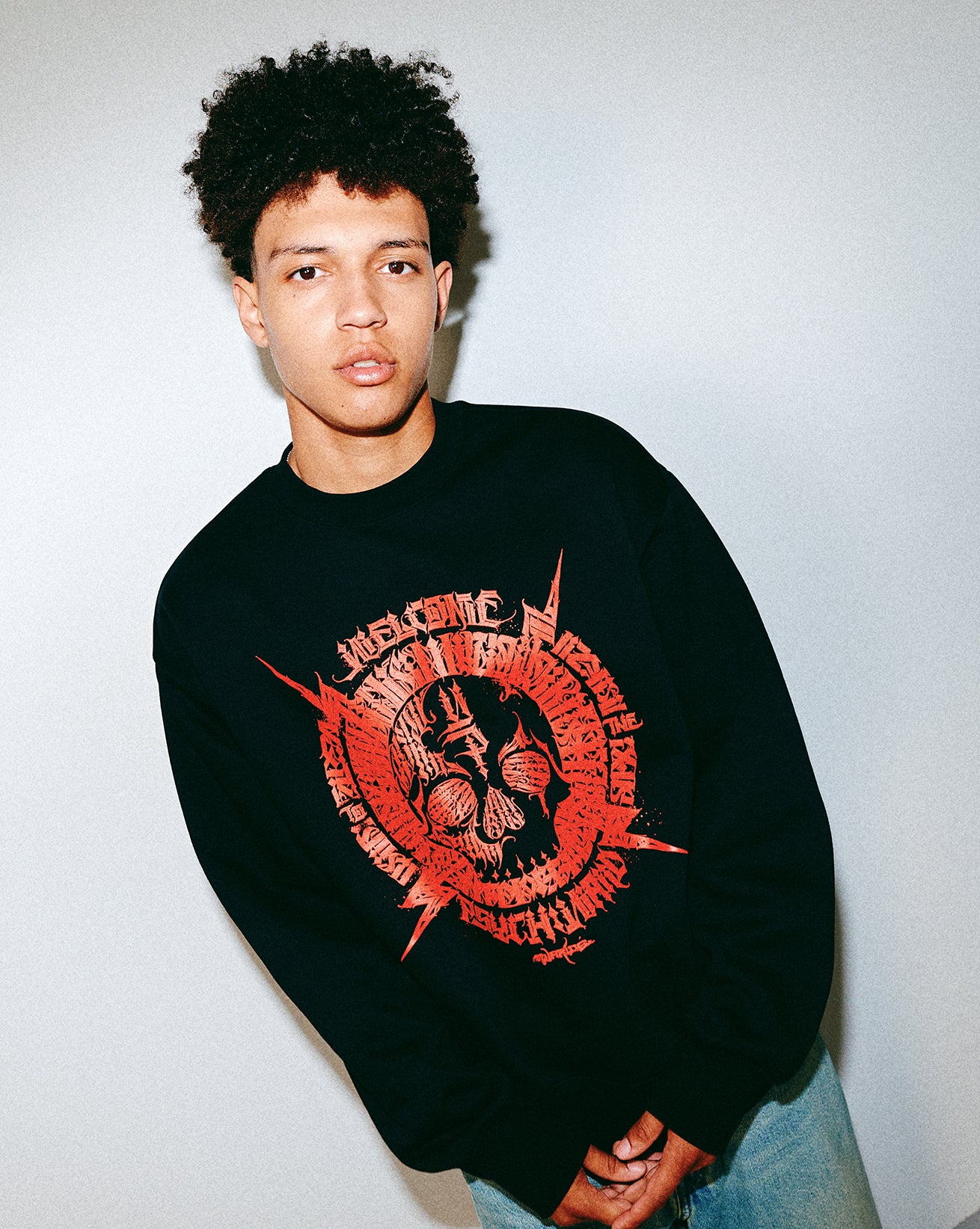 Person wearing a black sweatshirt with red Young Psychos graphic design on a plain background